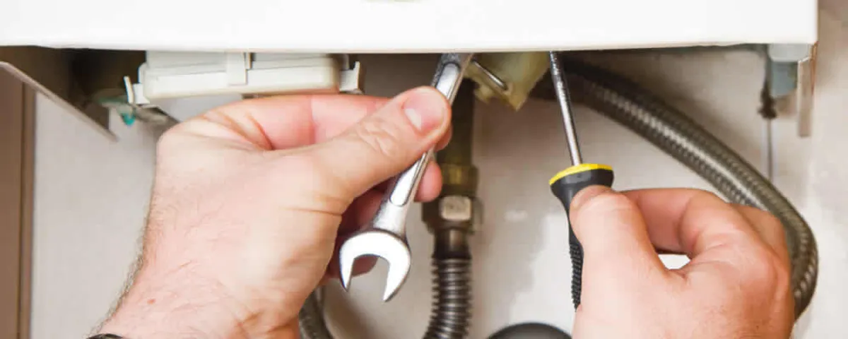 Boiler repair technician tightening pipe fittings and connections in New Orleans, LA