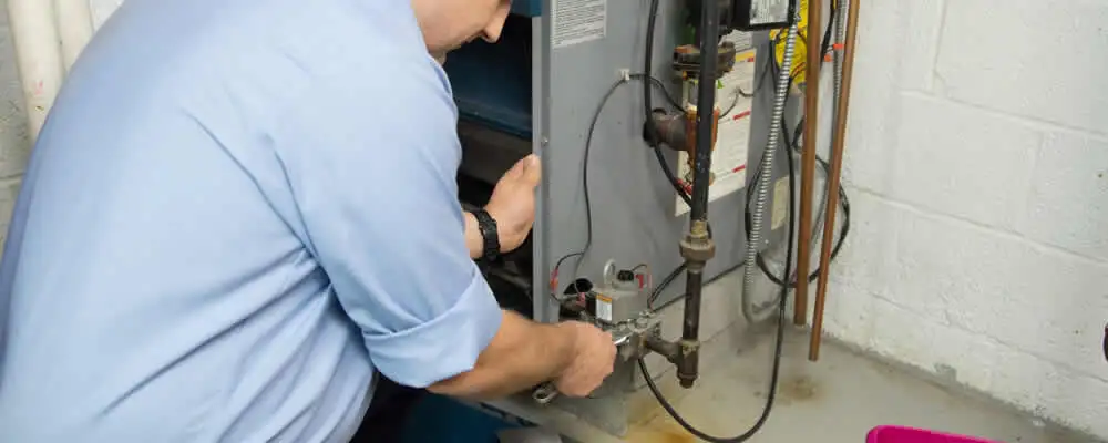Furnace repair technician inspecting and servicing a home heating system in New Orleans, LA