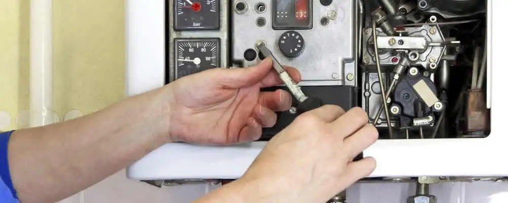 Heating repair technician adjusting boiler controls and components in New Orleans, LA