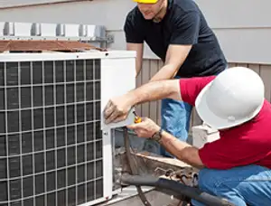 HVAC technicians repairing an outdoor AC unit on a rooftop in New Orleans, LA