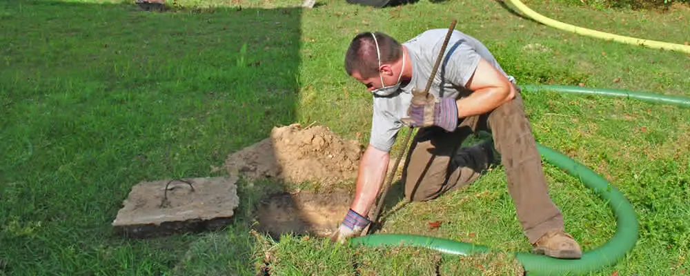 Septic pumping technician servicing a residential septic tank in New Orleans, LA